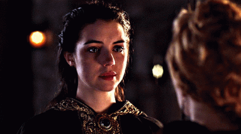 A Woman With Her Eyes Closed Looks Down At Something GIF