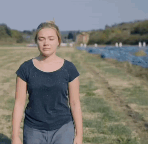 A Woman With Her Eyes Closed Standing In A Field GIF