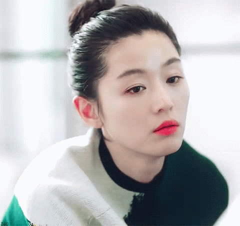 A Woman With Her Hair In A Bun And Red Lipstick GIF