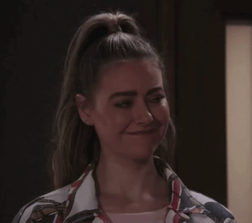 A Woman With Her Hair In A Ponytail Is Making A Silly Face GIF
