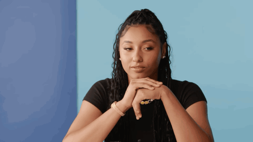 A Woman With Her Hands Folded Against Her Face GIF