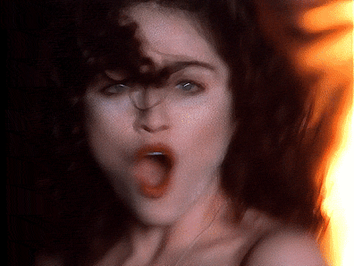 A Woman With Her Mouth Open And Fire In The Background GIF