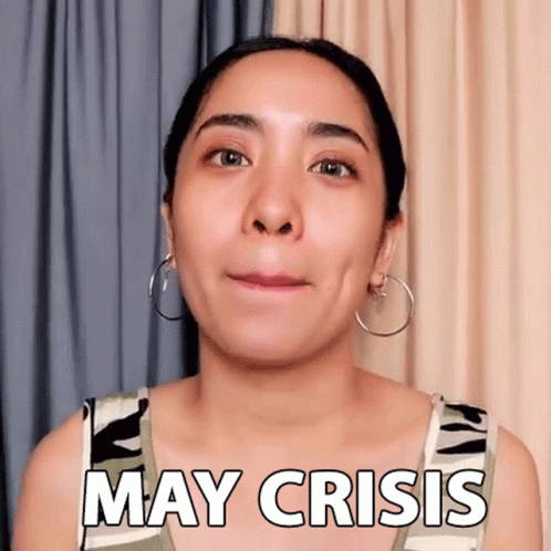 A Woman With Hoop Earrings Is Making A Funny Face And Saying May Crisis . GIF