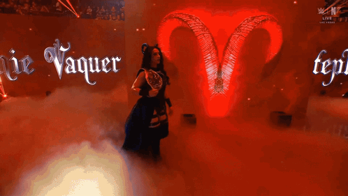A Woman With Horns And A Trophy In Front Of A Sign That Says Ie Vaquer GIF