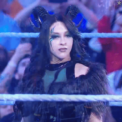A Woman With Horns Is In A Wrestling Ring With A Crowd Behind Her GIF
