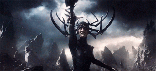 A Woman With Horns On Her Head Is Holding A Sword In The Dark . GIF