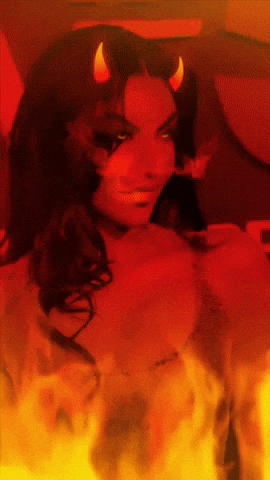 A Woman With Horns On Her Head Is Surrounded By Fire And Smoke GIF
