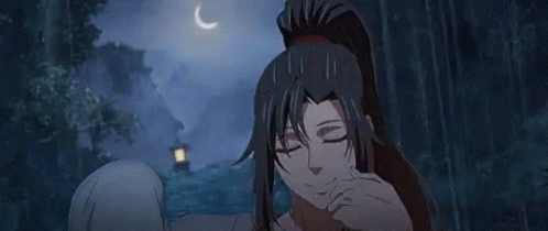 A Woman With Long Black Hair And A Ponytail Is Standing In A Forest . GIF