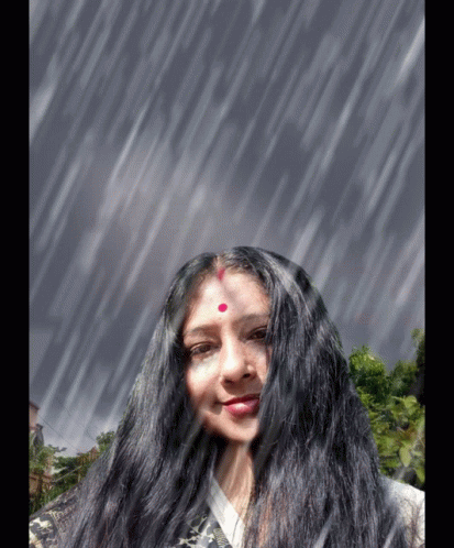 A Woman With Long Black Hair And A Red Dot On Her Forehead Smiles In The Rain GIF