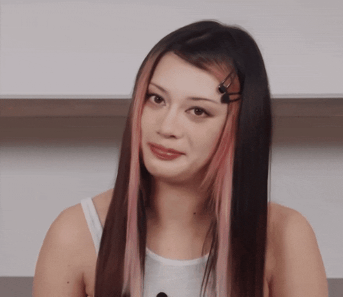 A Woman With Long Black Hair And Pink Streaks GIF