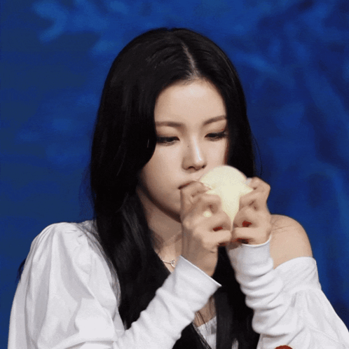 A Woman With Long Black Hair Is Holding A White Object GIF