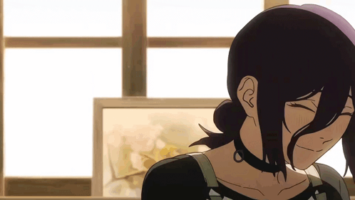 A Woman With Long Black Hair Is Smiling In Front Of A Window GIF