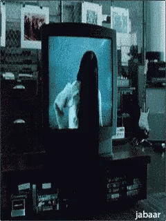 A Woman With Long Black Hair Is Standing In Front Of A Television Screen . GIF