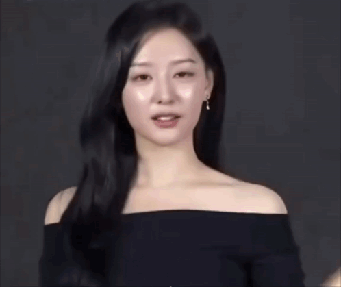 A Woman With Long Black Hair Is Wearing A Black Off The Shoulder Top GIF