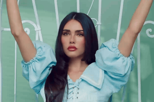 A Woman With Long Black Hair Is Wearing A Blue Shirt And Red Lipstick GIF