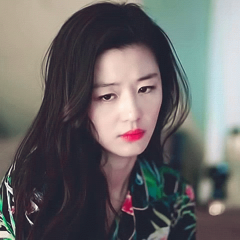 A Woman With Long Black Hair Is Wearing A Floral Shirt GIF