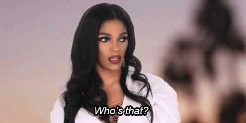 a woman with long black hair is wearing a white shirt and talking to someone .