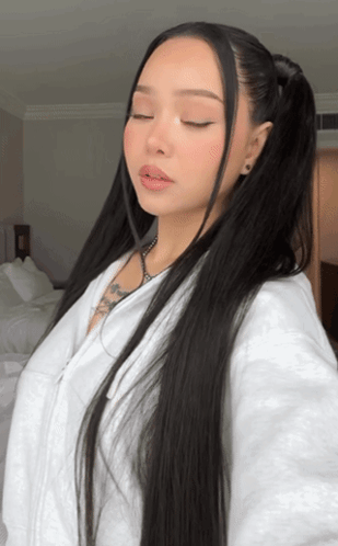 A Woman With Long Black Hair Is Wearing A White Sweatshirt GIF