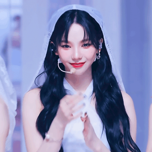 A Woman With Long Black Hair Wearing A White Dress And Veil GIF