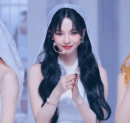 A Woman With Long Black Hair Wearing A White Dress And Veil . GIF