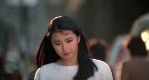 a woman with long black hair wearing a white shirt