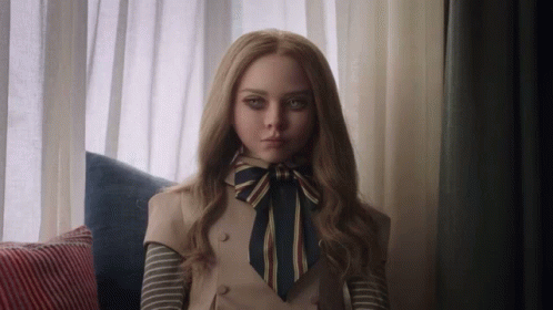 A Woman With Long Blonde Hair And A Bow Tie Is Sitting On A Couch GIF