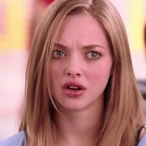 A Woman With Long Blonde Hair Is Making A Surprised Face . GIF