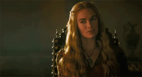 A Woman With Long Blonde Hair Is Sitting In A Chair GIF