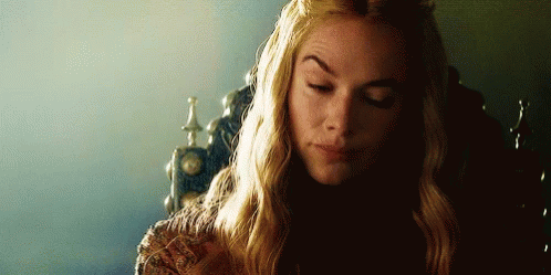 A Woman With Long Blonde Hair Is Sitting In A Chair With Her Eyes Closed And A Crown On Her Head . GIF