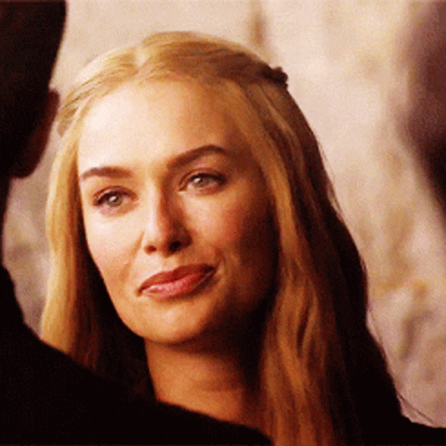 A Woman With Long Blonde Hair Is Smiling And Looking At The Camera GIF