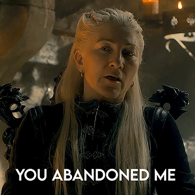 A Woman With Long Blonde Hair Is Standing In A Dark Room With The Words `` You Abandoned Me '' Written On The Bottom . GIF