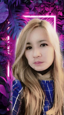 A Woman With Long Blonde Hair Is Standing In Front Of A Purple Background GIF