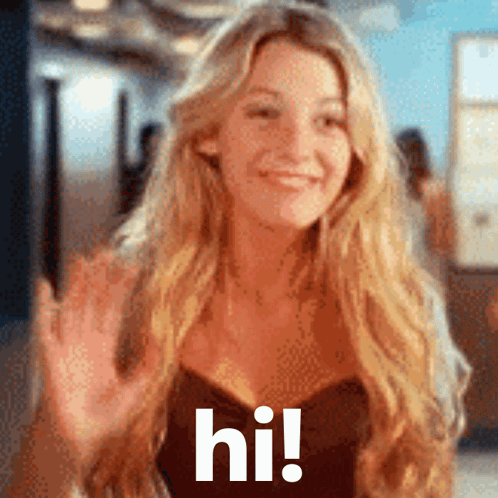 A Woman With Long Blonde Hair Is Waving Her Hand And The Words Hi Are Visible GIF