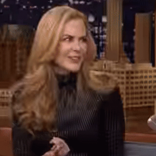 A Woman With Long Blonde Hair Is Wearing A Black And White Striped Shirt GIF