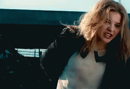 A Woman With Long Blonde Hair Is Wearing A Black Jacket GIF