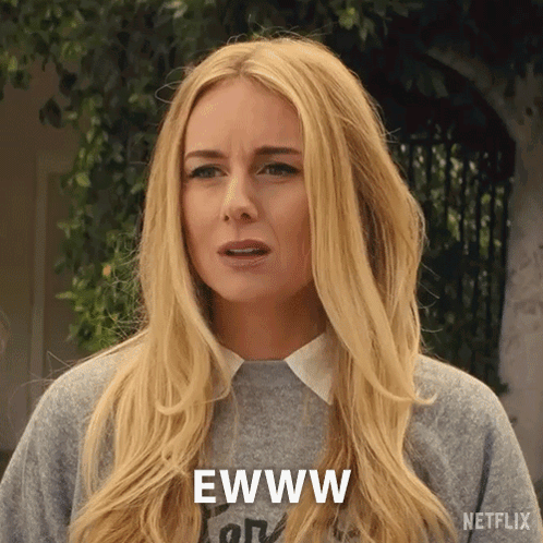 A Woman With Long Blonde Hair Is Wearing A Gray Sweater And Says Ewww GIF