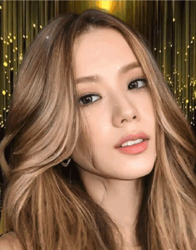 A Woman With Long Blonde Hair Looks At The Camera GIF