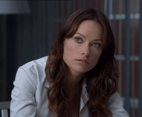 A Woman With Long Brown Hair And Blue Eyes Wearing A White Shirt GIF