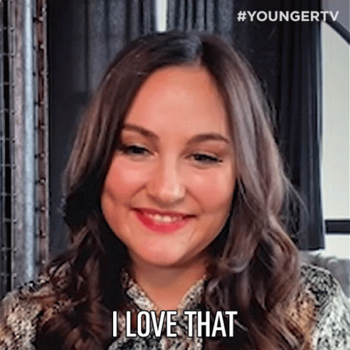 A Woman With Long Brown Hair Is Smiling And Saying `` I Love That '' . GIF