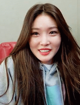 A Woman With Long Brown Hair Wearing A Grey Hoodie GIF