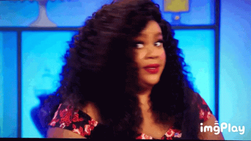 A Woman With Long Curly Hair Is On A Television Screen With A Blue Background And The Words Imgplay Below Her GIF