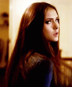 A Woman With Long Dark Hair Is Looking Over Her Shoulder . GIF