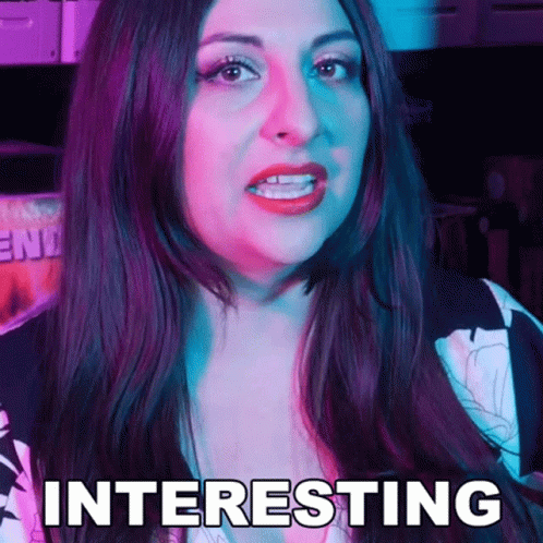 A Woman With Long Dark Hair Is Making A Funny Face And The Word Interesting Is On Her Face . GIF
