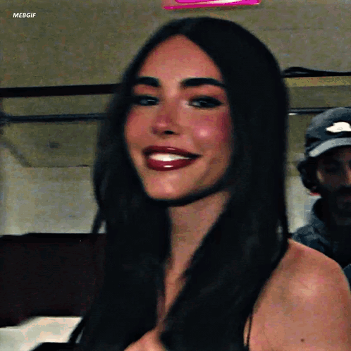 A Woman With Long Dark Hair Is Smiling For The Camera While Wearing Red Lipstick . GIF