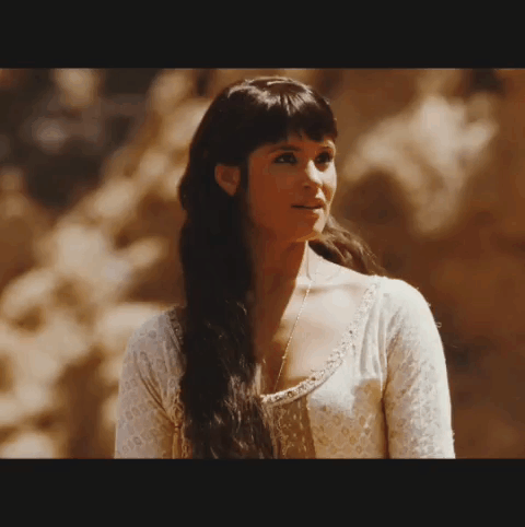A Woman With Long Dark Hair Wearing A White Shirt GIF