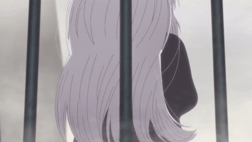 A Woman With Long Gray Hair Behind Bars GIF