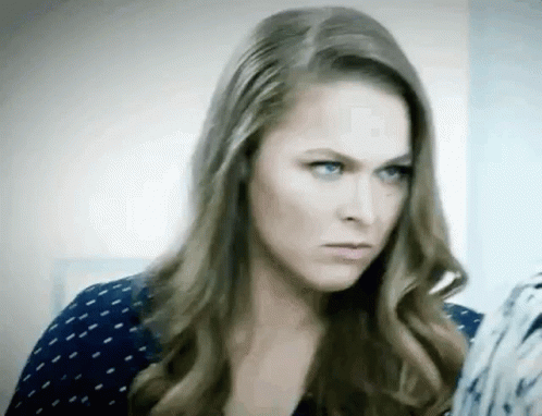 A Woman With Long Hair And Blue Eyes Is Making A Serious Face . GIF