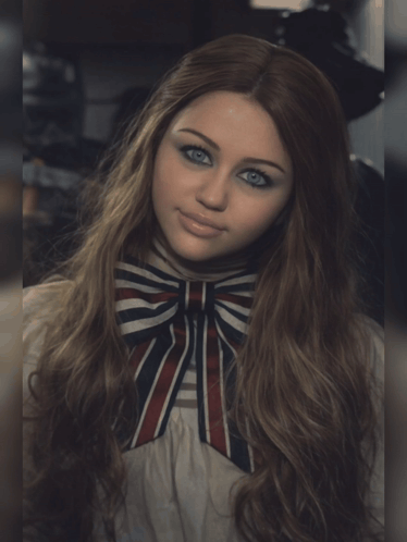 A Woman With Long Hair And Blue Eyes Wearing A Striped Bow Tie GIF