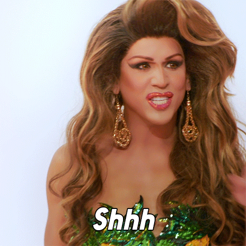 A Woman With Long Hair And Earrings Says Shhh On Her Face GIF