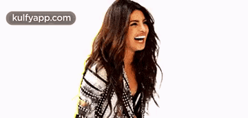 A Woman With Long Hair Is Laughing While Wearing A Striped Shirt . GIF
